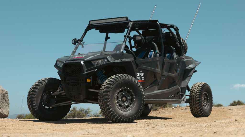 A Polaris RZR with Kemimoto Logo parked on the road-1