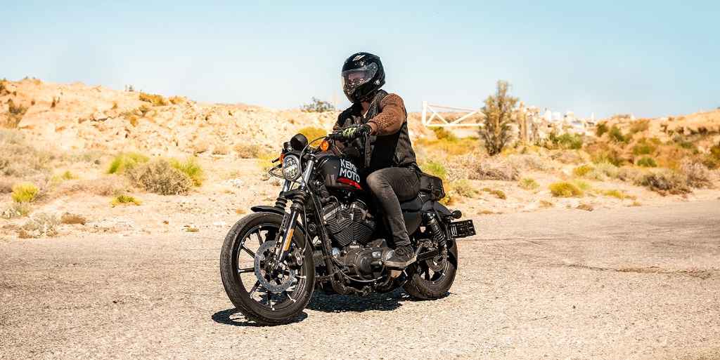 A man riding a motorcycle with the “KEMIMOTO” Logo-1