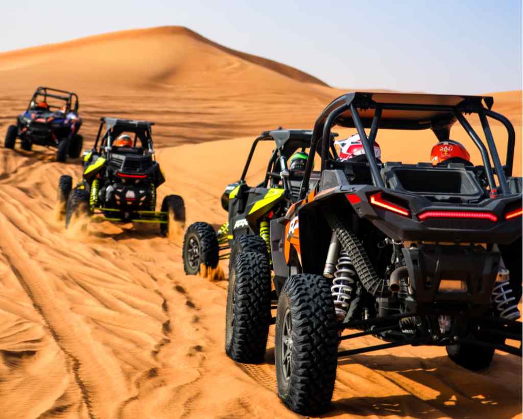 Guys riding Polaris RZR on the sand dune