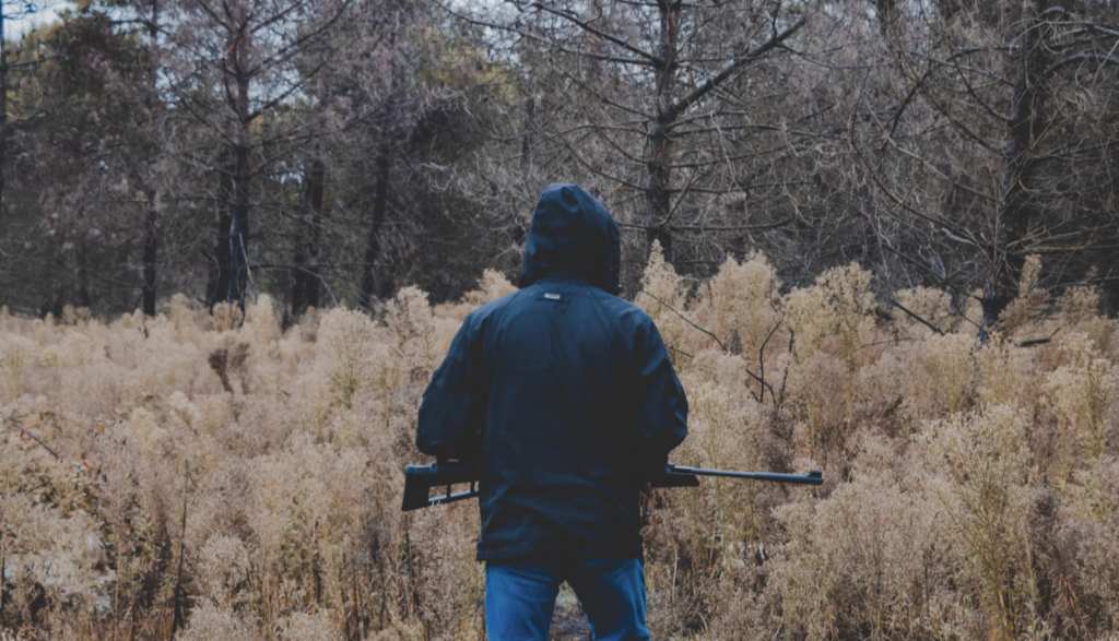 Hunter with Rifle Facing the Tree Line