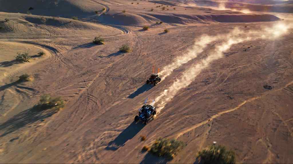 Two UTVs running fast in the desert