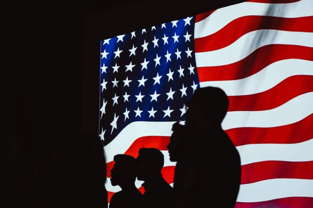 en standing in front of the U.S. flag