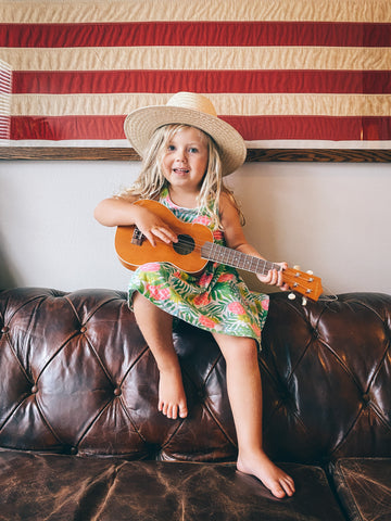 little girl playing a ukulele