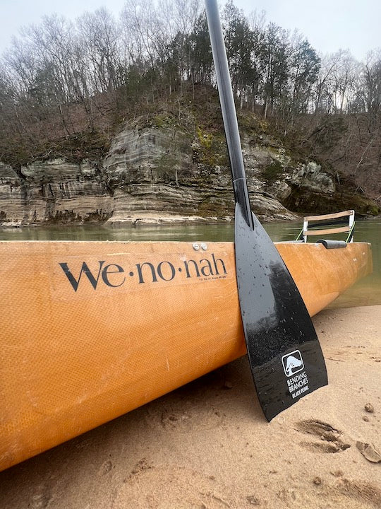Bending Branches Black Pearl canoe paddle next to a Wenonah canoe on the riverbank, Meramec River
