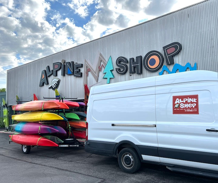 Alpine Shop building with van and kayak trailer parked in front