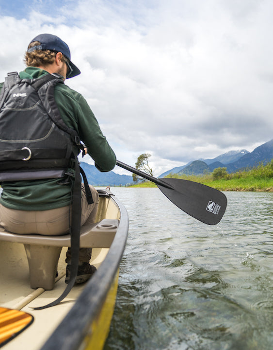 man in bow of a canoe on a lake