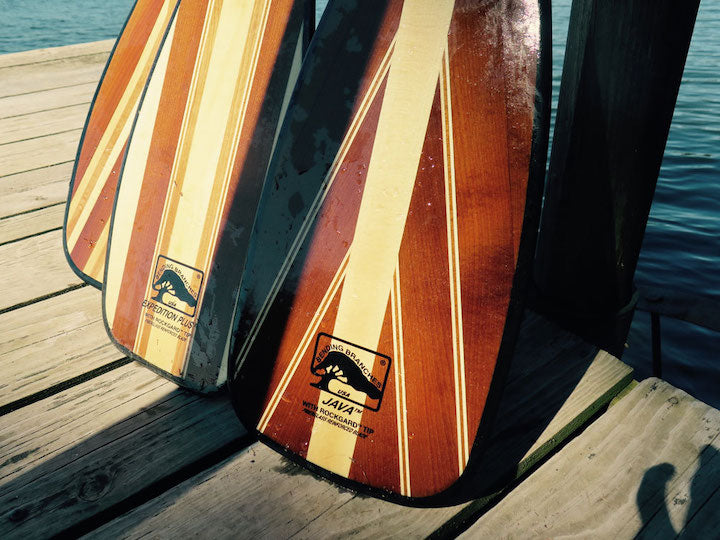 three wood canoe paddles
