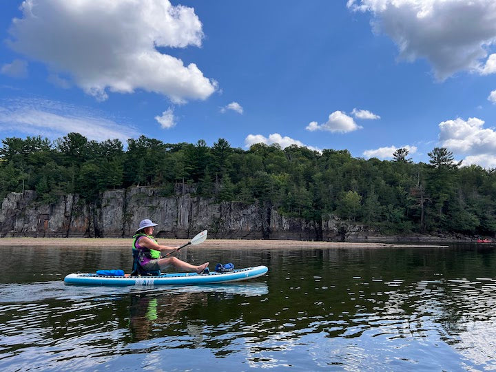 woman on SUP/kayak hybrid, kayaking on a river