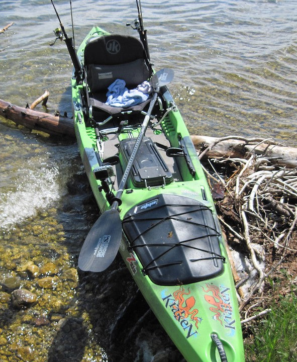 Sit-on-top fishing kayak on shore with Bending Branches paddle and gear