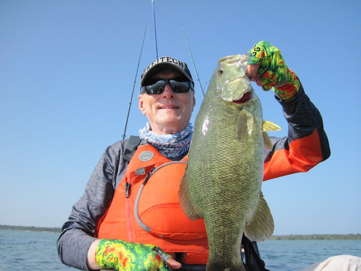 Bill Schultz holding up a nice smallmouth bass