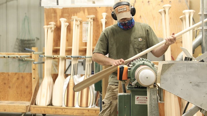 sanding a wood canoe paddle