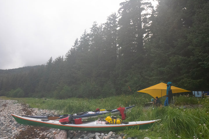 basecamp with kayaks, tarp and gear