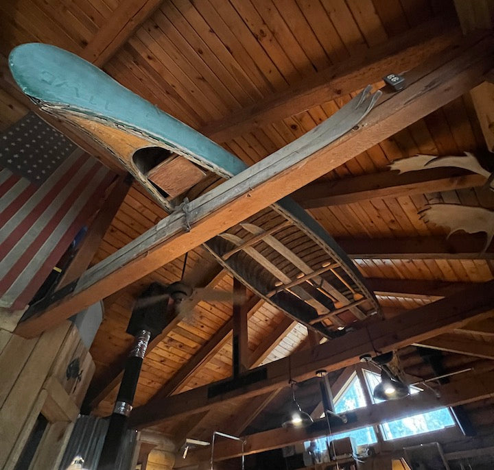 old canoe and paddles in the rafters in a rustic lodge