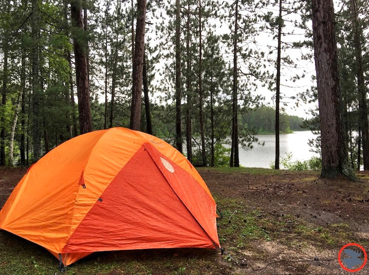 orange tent at a canoe campsite in sylvania wilderness