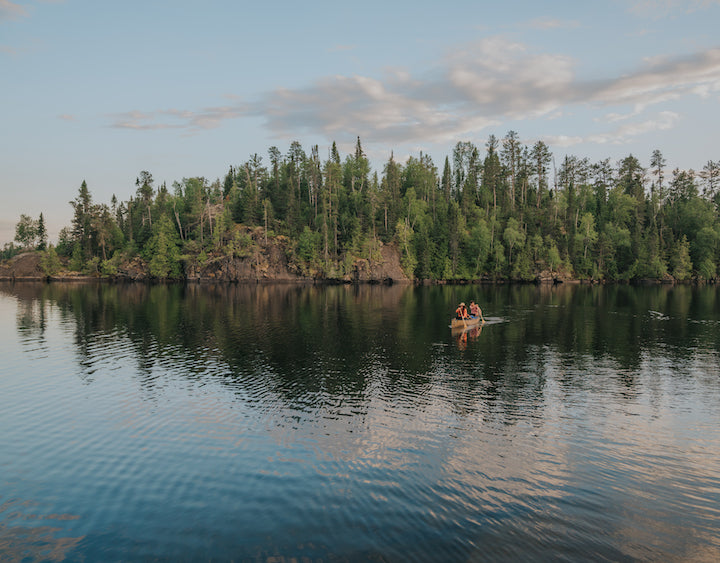 two people in a canoe on a northern lake from the distance