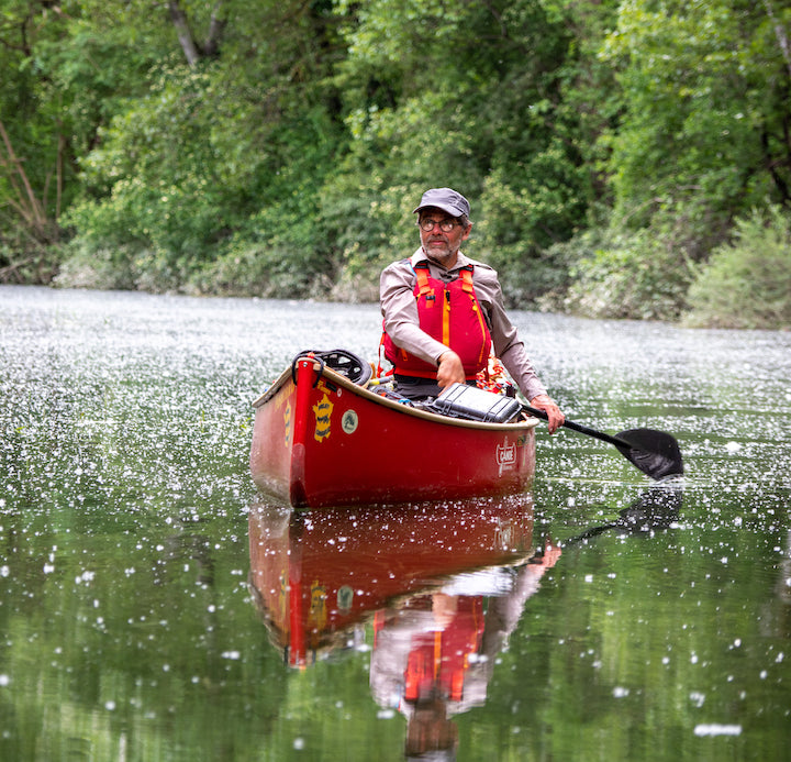 man in red canoe using an all-carbon paddle