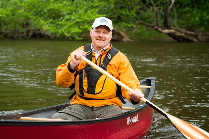 Ed Vater in a canoe, long-time Bending Branches President and owner