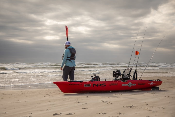 a kayak angler prepares to head out on the ocean on a windy day