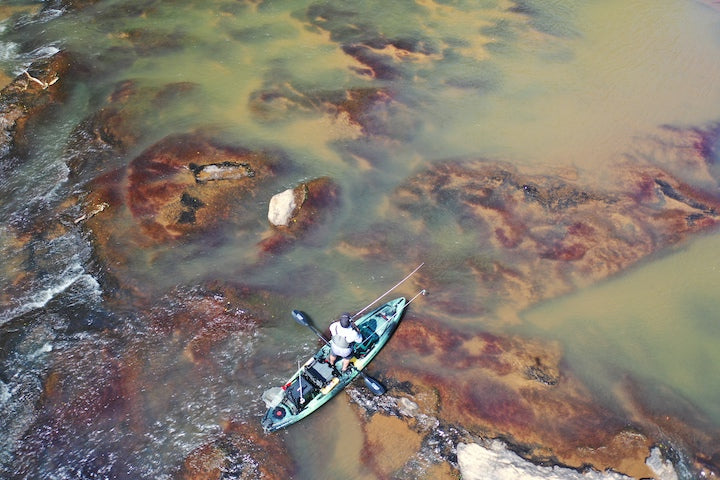 drone shot of a kayak angler fishing on a river