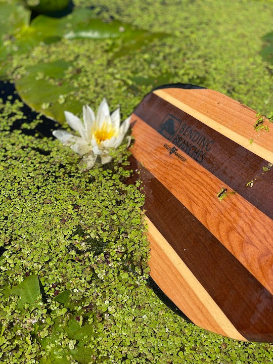 Navigator Pro paddle blade next to a water lily on the water's surface