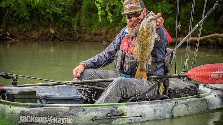 man lifting up a big fish from a Jackson Kayak