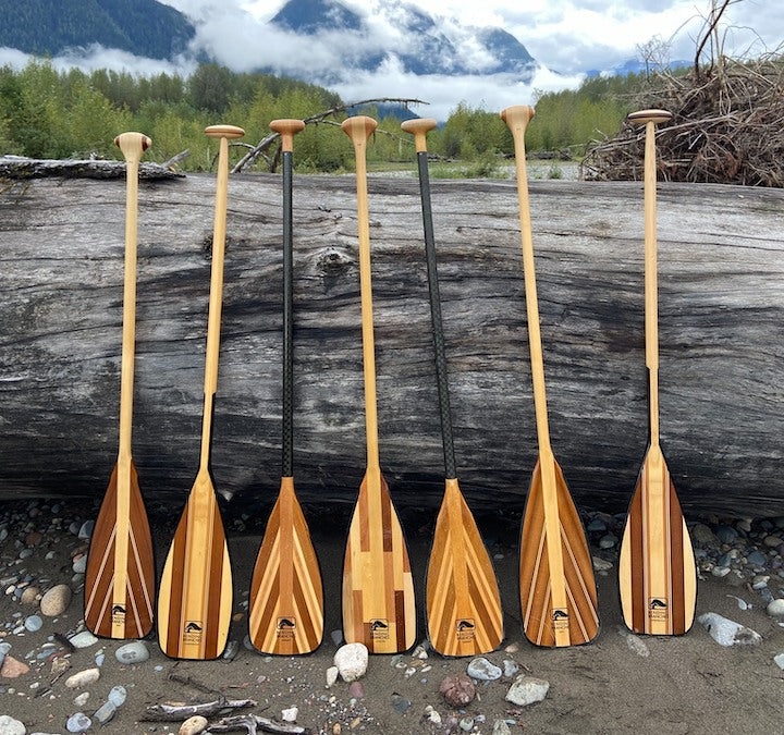 7 Bending Branches wood canoe paddles against a huge log