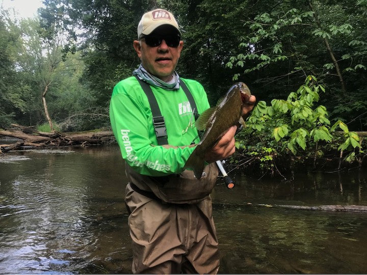 Steve Hrynewycz standing in a river with a fish