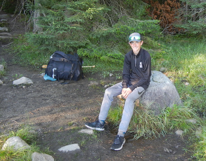 weston strege sitting on a rock at a portage