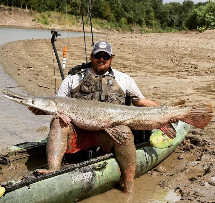 big man in a kayak with a big fish
