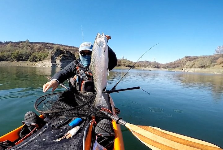 Moo Lee in his fishing kayak with a fish