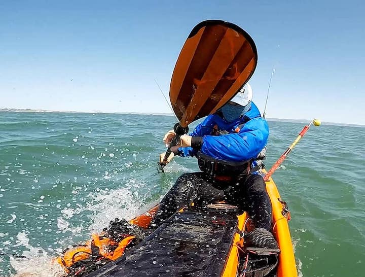 Moo Lee paddles his fishing kayak on the ocean with Bending Branches Navigator kayak paddle