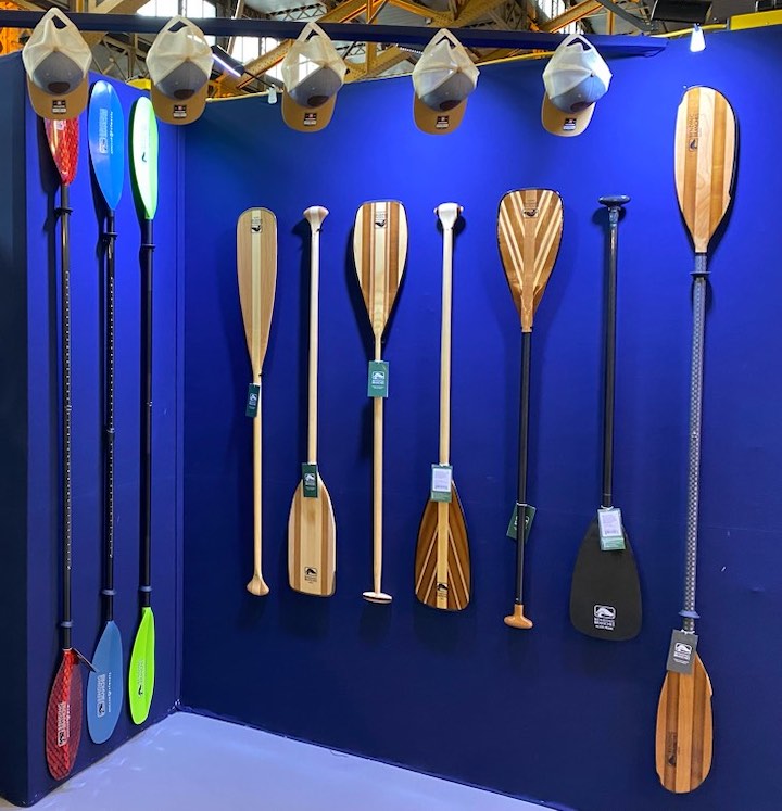 several Bending Branches paddles on a display at an expo