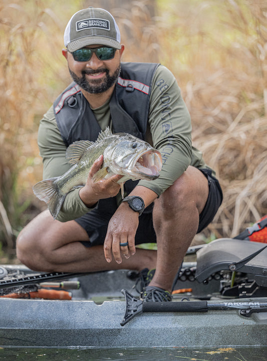 Terrell Hester in his fishing kayak, holding a nice bass