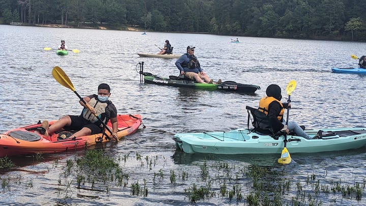P4T participants and volunteers kayak on a local lake