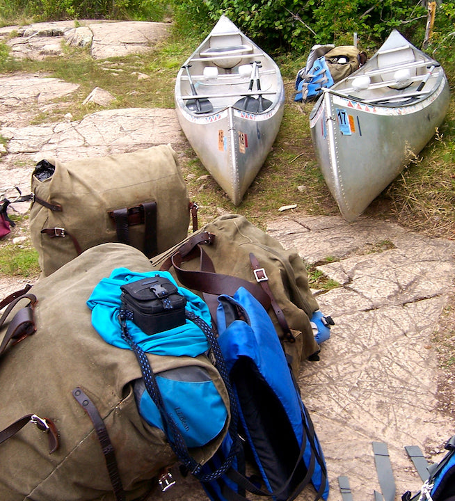 canoes and loaded packs at a portage
