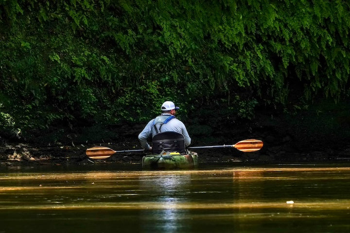 man in shadows in a fishing kayak with Bending Branches Angler Navigator paddle