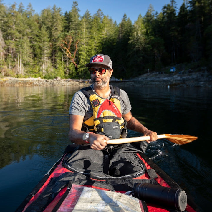 man paddling in the stern of a canoe on a wilderness trip