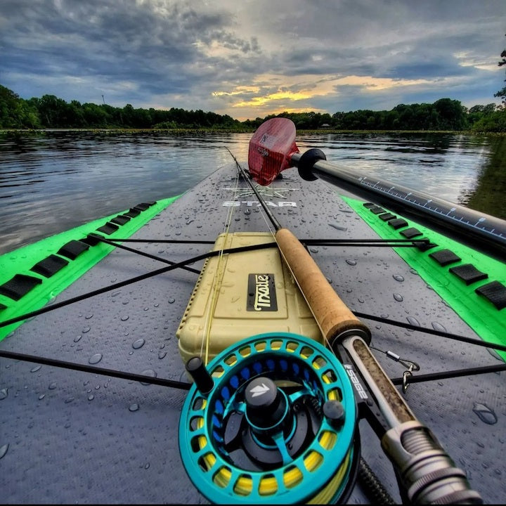 close up of a fly rod and paddel on paddle board