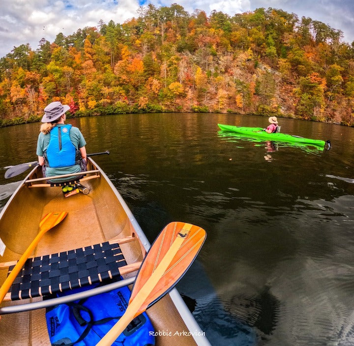 canoeists and kayaker on a lake in the fall