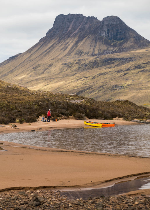 canoes pulled up along a sand beach in Scotland