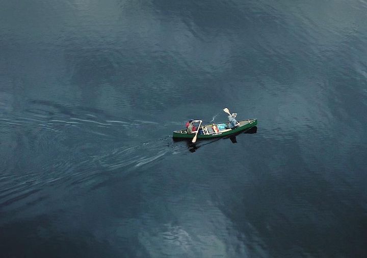 drone view of two canoeists paddling a loaded canoe