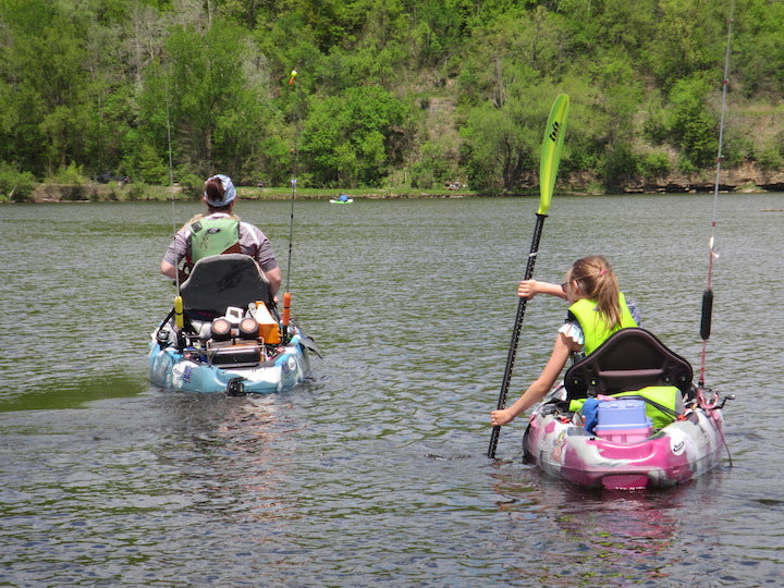 Woman and girl on their own fishing kayaks