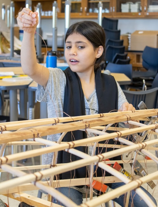 A school girl works on an Urban Boatbuilders canoe