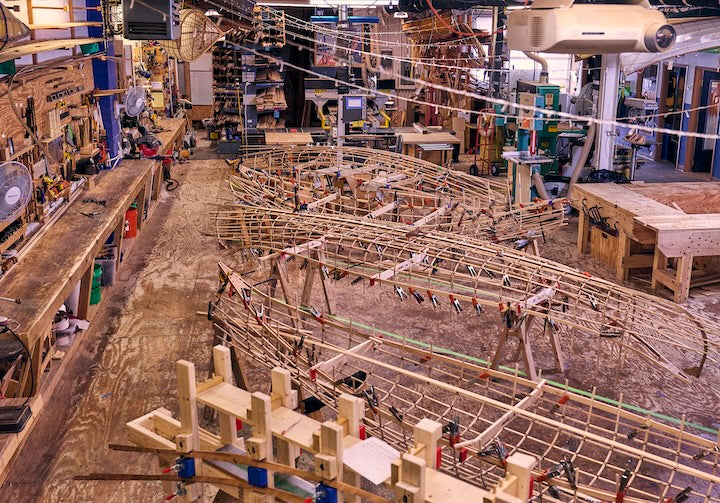 Inside Urban Boatbuilders' shop with several boats in progress