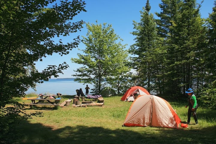 kayak campsite with two tents, picnic table