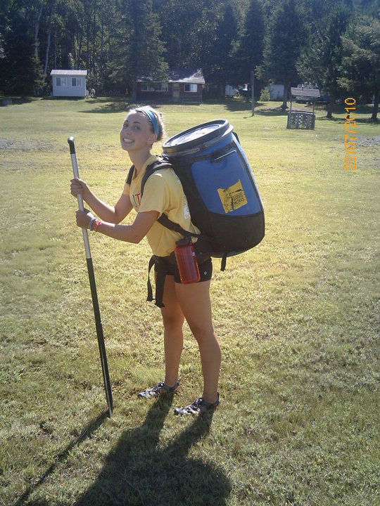 Mikaela Ferguson carrying a barrel while portaging
