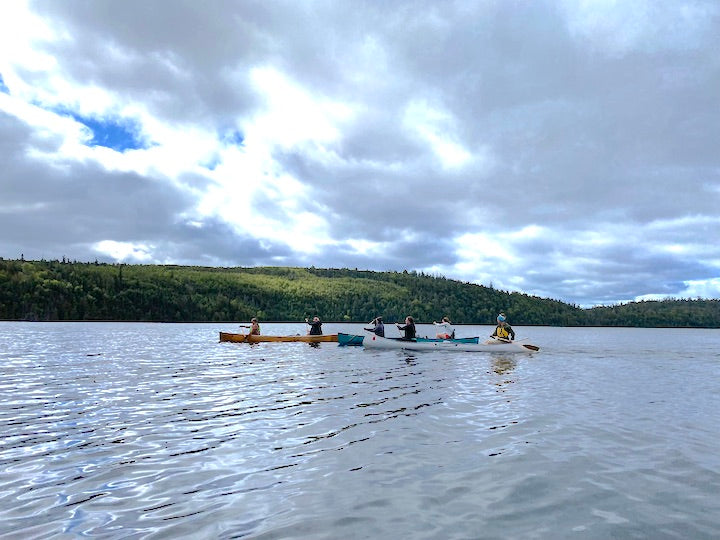 six women in three canoes paddling a Boundary Waters lake