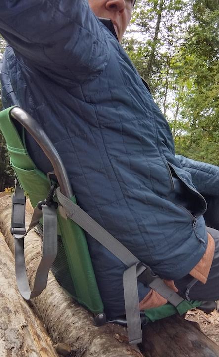 woman sitting on stadium seat on logs at campsite