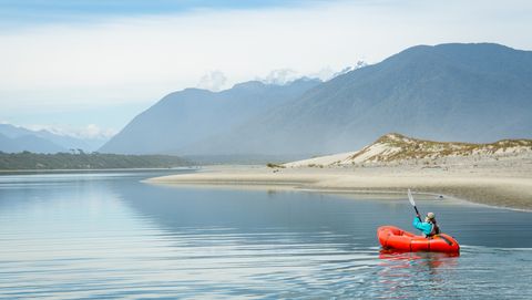 Packrafting in New Zealand next to a soft sandy shoreline