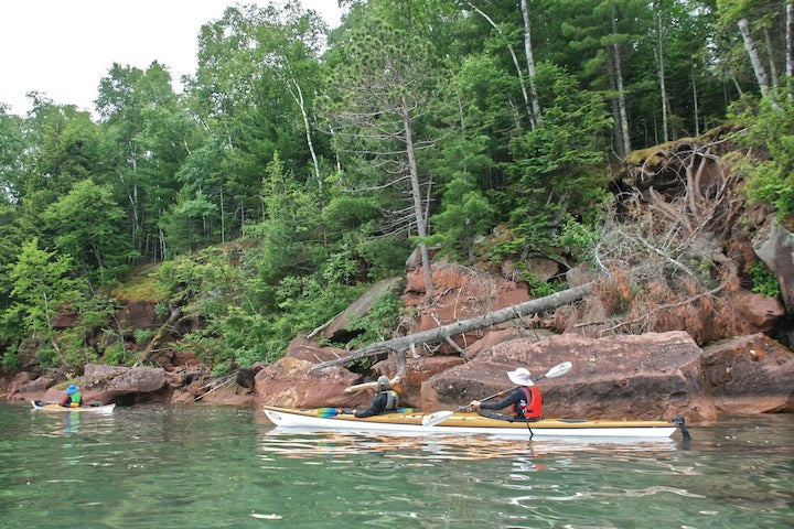 kayakers along a rocky shoreline